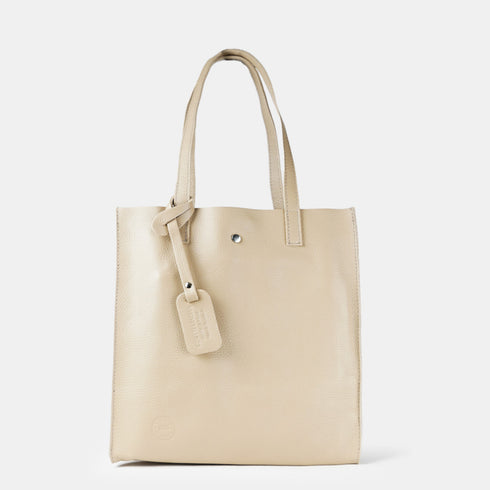 Bolso estilo tote bag con etiqueta para mujer de color kahki con piel genuina de calidad en vista frontal.